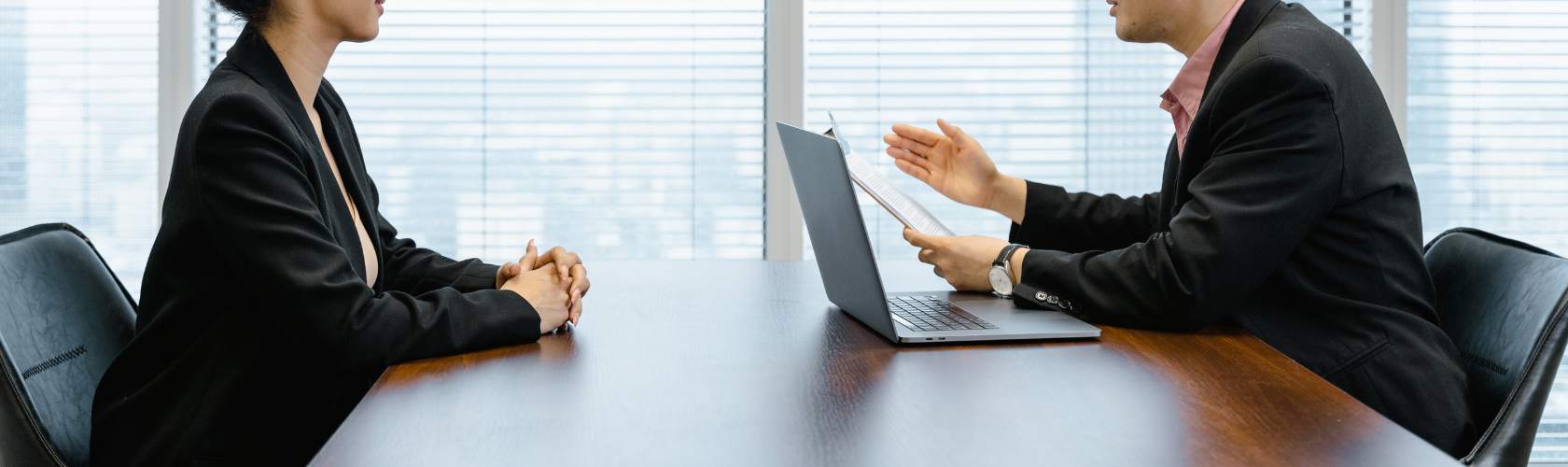 Two people sitting at a desk doing an interview