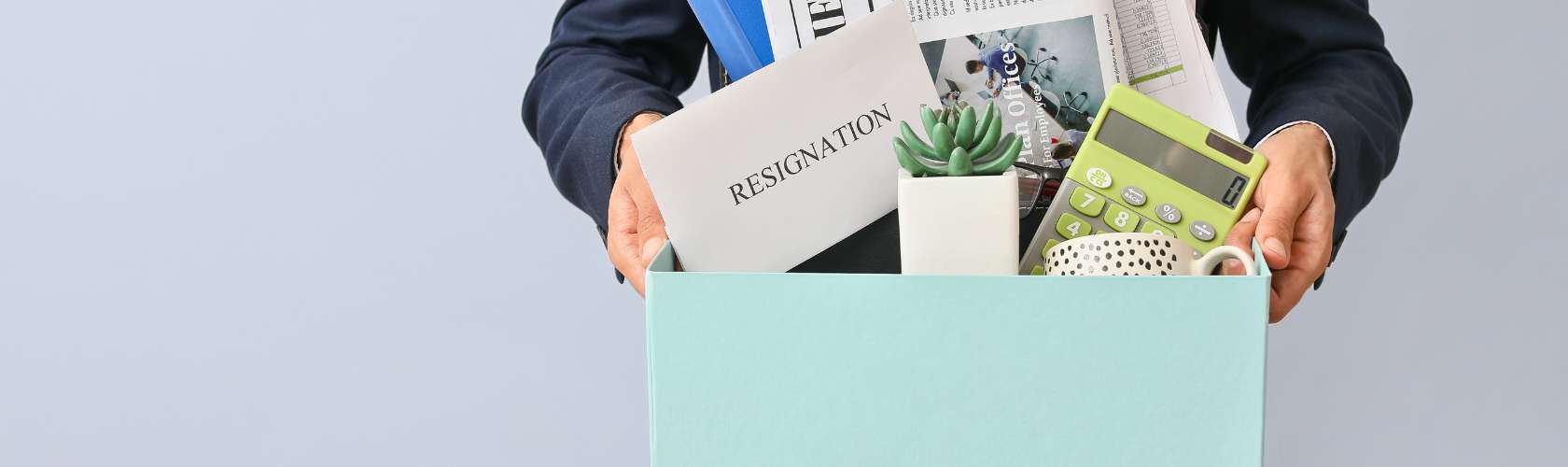 Man carrying his things in a box with a letter of resignation